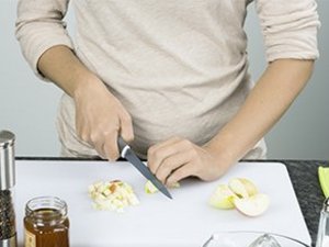 Eine Person schneidet einen Apfel in kleine Würfel.